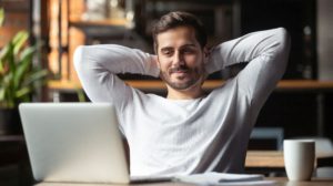 Man with beard in front of laptop relaxed after bidding